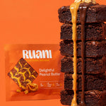 RUANI Delightful Peanut Butter functional brownie stack with peanut butter and chocolate drizzle beside the product pack