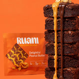 RUANI Delightful Peanut Butter functional brownie stack with peanut butter and chocolate drizzle beside the product pack